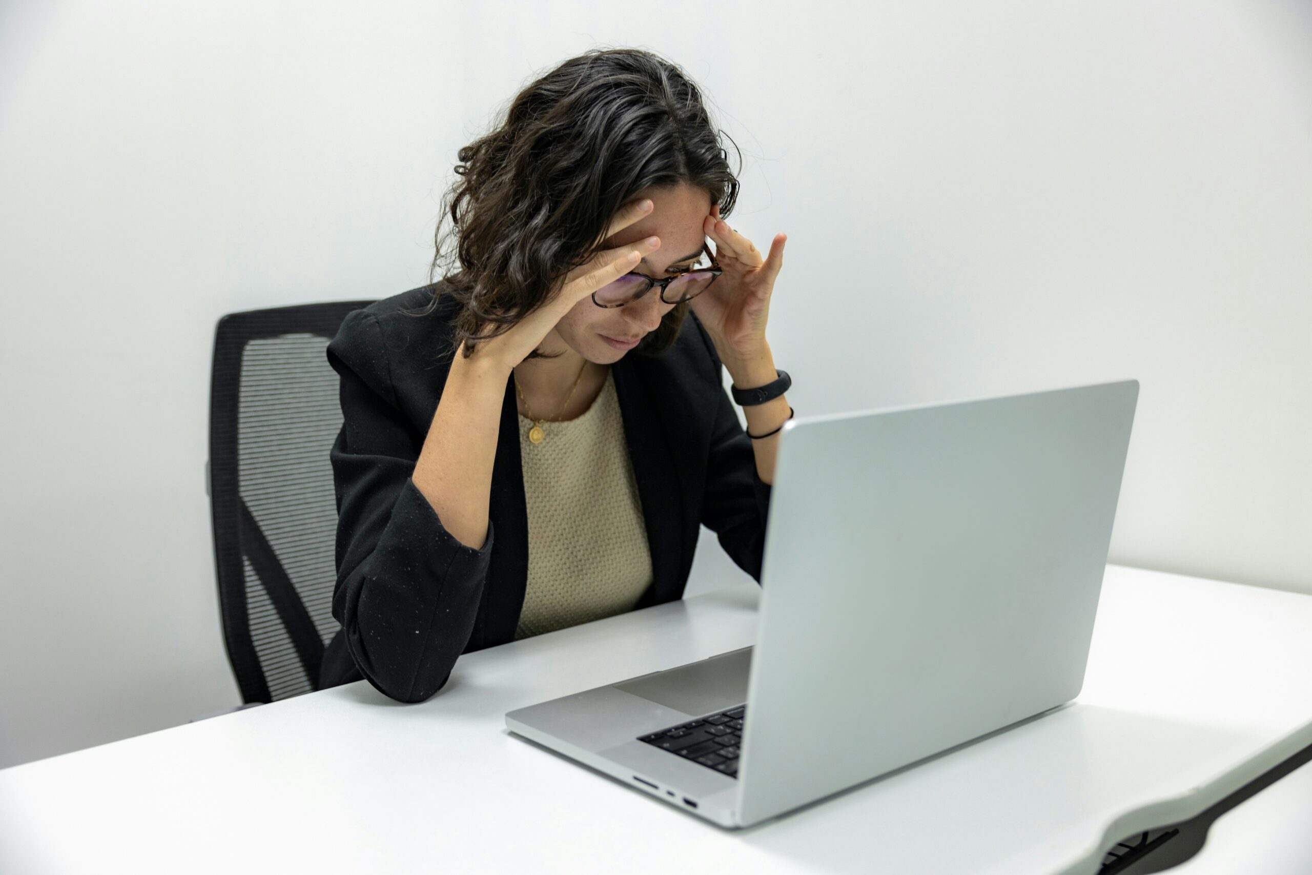 Wenn der Job das Privatleben frisst: Erschöpfte Person am Abend, Laptop noch offen